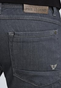 Dunkelgraue Denim-Jeans mit einem Leder-PME-Legend-Label, ausgestattet mit einer Gesäßtasche mit gesticktem Detail und einem kleinen gestickten Logo.