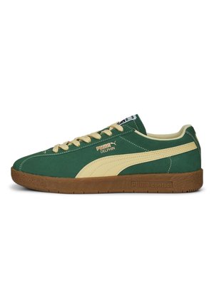 Zielony sneaker Puma Delphin z beżowym paskiem i sznurowadłami, brązową teksturowaną podeszwą oraz logo Puma na boku i podeszwie.