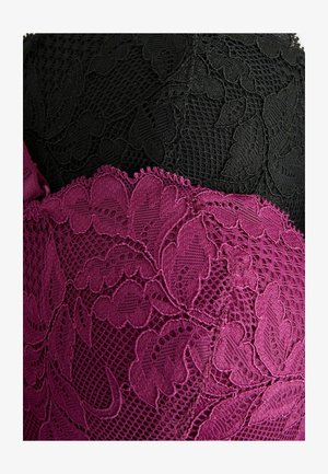 Svart och vinröd spets tyg med blommönster och vågiga kanter, lager med intrikata texturer och mönster.