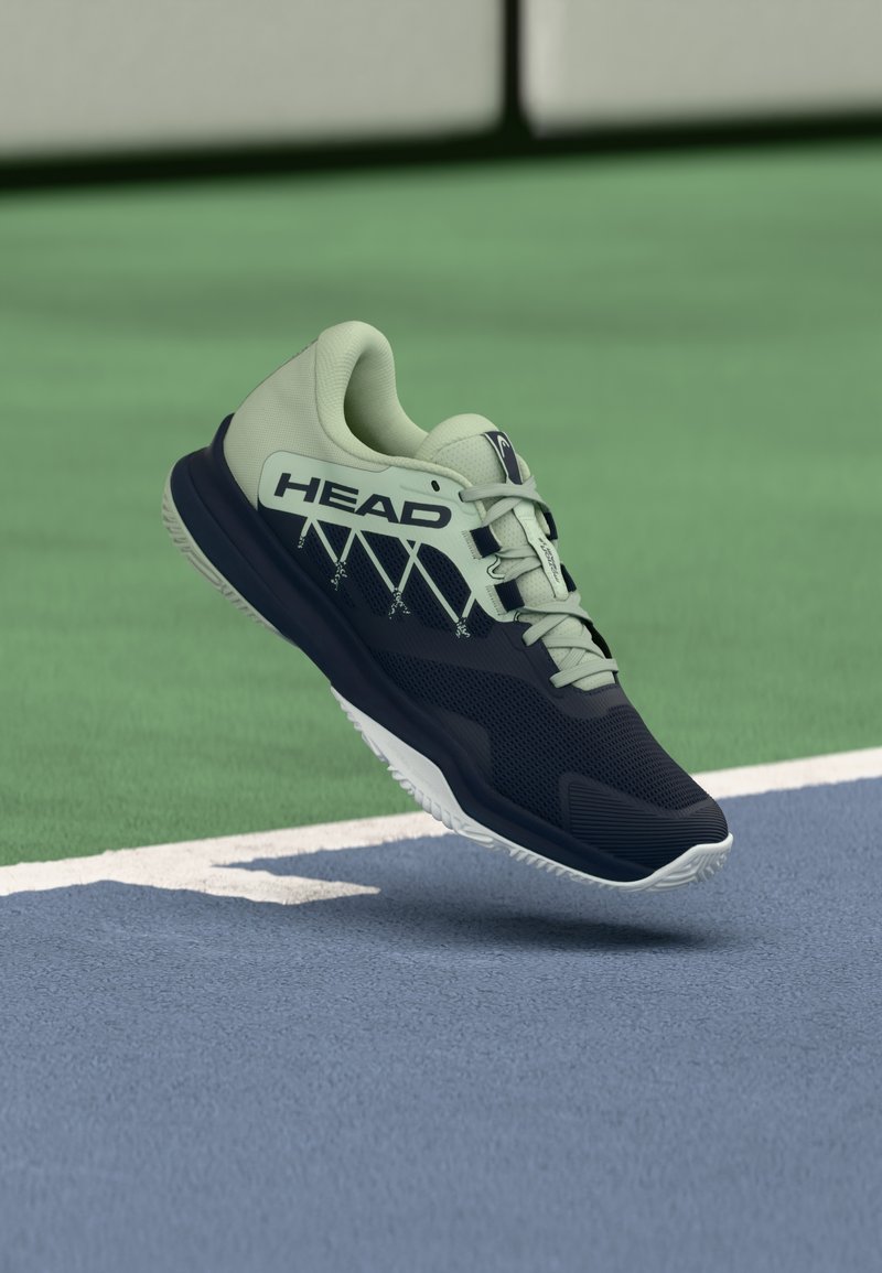 Tumedas sinises ja helerohelises värvitoonis spordijalats. Pealiskihiks on võrgumaterjal tekstuuriga pinnaga, kontrastsed detailid ning valge libisemisvastase tallaga outsole.