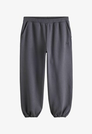 Dark gray elastic waist sweatpants with side pockets and elastic cuffs at the ankles, made of soft fabric.