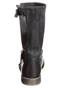 Bottine en cuir noir avec une finition lisse, bout arrondi et un léger talon. Elle présente une sangle sur le côté et des détails de couture subtils.