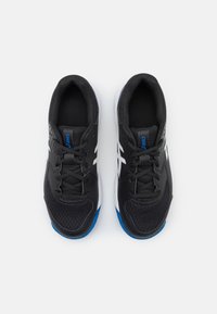 Baskets de sport noires avec une tige en maille, surface texturée, accents blancs et semelles bleues. Comprend des lacets et un intérieur rembourré.