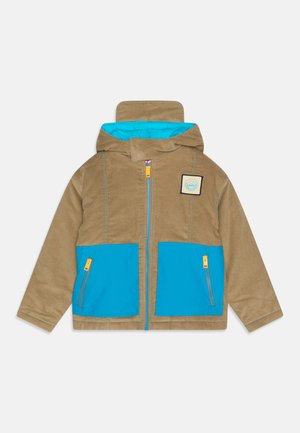 Brun cordfløjl jakke med blå indvendig og to forlommer. Har en lynlås lukning og et logo-patch på brystet.