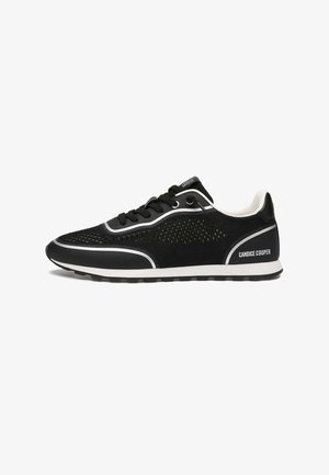 Zapatilla deportiva negra con parte superior de malla, acentos blancos y cordones. Presenta una suela contrastante y un logo en el talón. Diseño ligero.