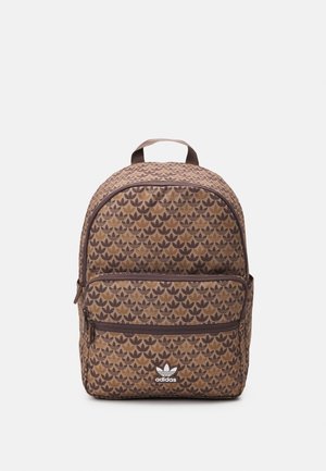 Brązowy plecak Adidas z nadrukiem całopowierzchniowym z logo trefoil, przednią kieszenią na zamek błyskawiczny i górną rączką do przenoszenia, na jednolitym jasnym tle.