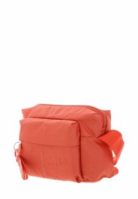 Sac bandoulière en tissu rouge avec surface texturée, forme incurvée, compartiment principal zippé et poche avant avec petit détail métallique.