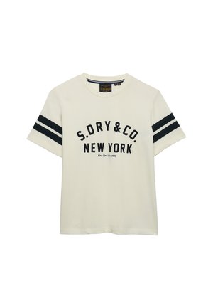 Camiseta de color crema de manga corta con doble rayas negras en las mangas y texto negro "S.DRY&CO. NEW YORK" en la parte delantera.