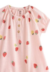 Ljust rosa kortärmad klänning gjord av mjukt tyg, med en elastisk halsringning, tre träknappar och spridda röda och gula jordgubbstryck.