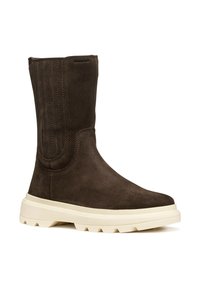 Botas de tobillo de ante marrón con superficie texturizada, suela de goma crema y acentos de costura vertical. Diseño impermeable para mayor durabilidad.