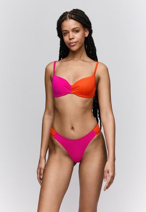 Bikini in roze en oranje kleurblokontwerp, met een geplooide voorkant op het bovenstuk en zijkanten op het onderstuk. Gladde stoftextuur.