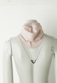 Grauer Mannequin-Oberkörper, der ein weiches, rosafarbenes Stoffhalsband trägt, von hinten vor einem schlichten weißen Hintergrund gezeigt.