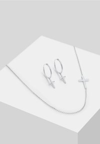 Silbernes Schmuckset mit Creolenohrringen mit Kreuzanhängern und einer Halskette mit einem Kreuzanhänger, alles mit einer polierten Oberfläche.