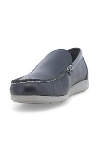 Scarpe slip-on in pelle blu marina con dettagli cuciti, suola in gomma piatta e punta arrotondata. Texture liscia e design minimalista.