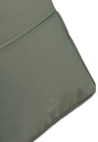 Sac à dos en tissu texturé vert avec une poche zippée et un logo "Bench" en relief. Forme rectangulaire avec des détails de couture renforcés.