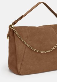 Brown suede handbag with a structured shape, featuring a detachable gold chain strap and embossed logo detail on one side.