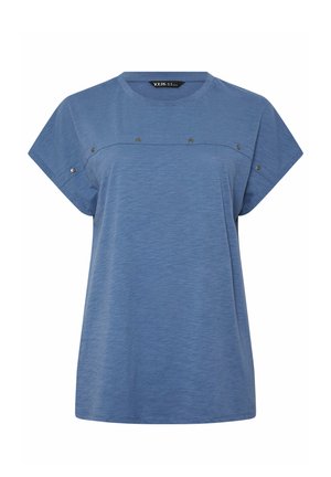 Top azul de manga corta y corte holgado con escote redondo y tachuelas metálicas decorativas a lo largo del pecho y las mangas.