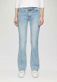 Lichtblauwe uitlopende jeans van denim, met een standaard ontwerp met vijf zakken, subtiele vervaging en een middelhoge taille. Draag met witte sneakers.