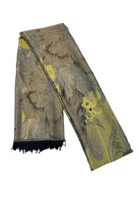 Écharpe tissée présentant un motif floral dans des tons atténués de vert et de beige, terminée par un bord frangé noir. Le tissu texturé apporte de la profondeur.