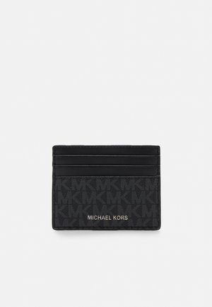 Porta-cartões preto feito de material sintético texturizado, apresentando um padrão em relevo com o logótipo "MK", cinco slots para cartões e "MICHAEL KORS" em letras douradas.