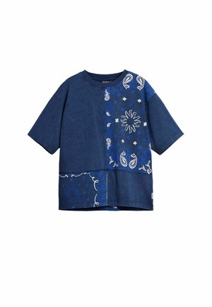 Blå denim t-shirt med korte ærmer, prydet med paisley- og blomstermønstre i hvid og lysere blå på venstre forside.