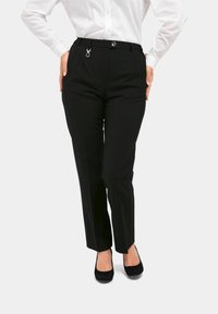 Zwarte op maat gemaakte broek met een rechte pijp, voorzien van een zilveren lus detail in de taille, en klassieke zwarte hoge hakken.