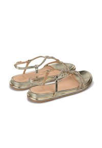 Sandalias metálicas doradas con tiras en forma de T decoradas con cuentas, suelas planas y una plantilla de cuero suave. Diseño abierto, adecuado para clima cálido.