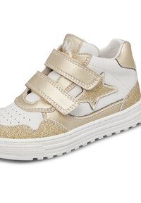 Vita och guld atletiska skor med två kardborreband, en stjärnaccent och glittrande detaljer på häl och tå.