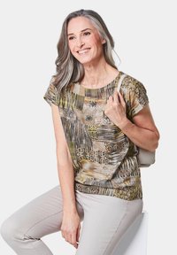 Bedrukt T-shirt met korte mouwen en een ronde halslijn, in aardeachtige bruin-, groen- en geeltinten. Gladde stof met gevarieerde geometrische patronen.