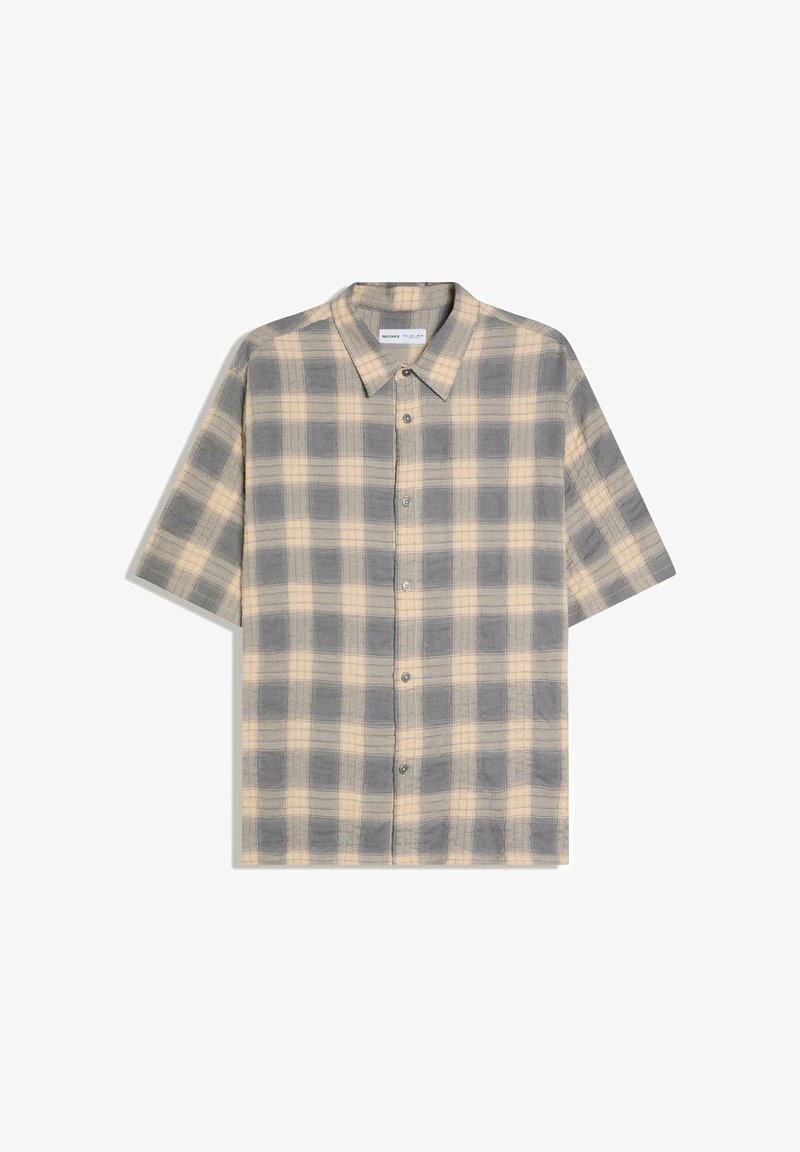 Chemise à manches courtes beige et grise à carreaux, boutonnée avec un col, présentée à plat sur fond blanc.