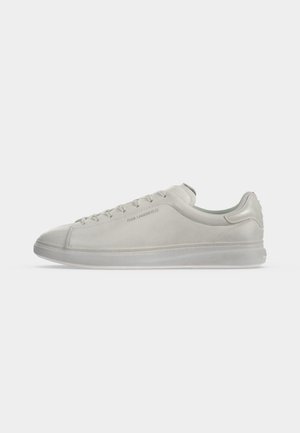Λευκό δερμάτινο sneaker χαμηλού ύψους με κορδόνια μπροστά, διακριτικά ράμματα και λογότυπο ανάγλυφο στο πλάι κοντά στα κορδόνια.