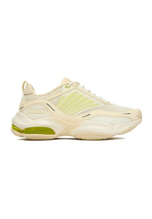 Zapatilla deportiva Reebok beige y amarillo claro con lados de malla, amortiguación dinámica de aire y una cámara de aire visible en la suela.