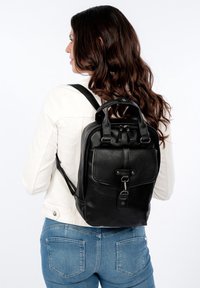 Czarny skórzany plecak z teksturowaną powierzchnią, górnym uchwytem, regulowanymi paskami oraz przednią kieszenią z metalowym wykończeniem.