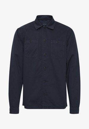 Námořnická modrá košile na knoflíky vyrobená z bavlněné směsi, má límec, dvě přední kapsy a dlouhé rukávy s knoflíkovými manžetami.