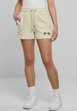 Beige Sweatshorts mit elastischem Bund, Kordelzug, seitlichen Taschen und Logodetail. Hergestellt aus weichem Stoff, mit einem lässigen Schnitt.