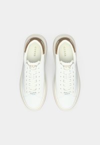 Hvite lær sneakers med en glatt tekstur, med en beige aksent nær kragen, rund tå og tradisjonelt snøresystem.
