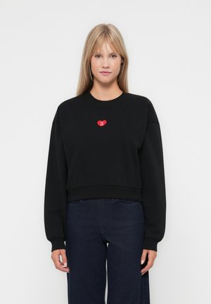 Zwart cropped sweatshirt met lange mouwen en ribgebreide boorden, met een rode hartapplicatie op de borst. Glad materiaal, casual fit.
