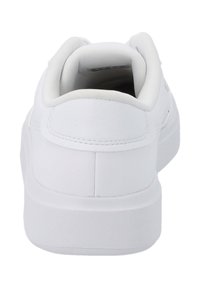 Vit sneaker med en slät läderliknande yta, rund häl, vadderad krage och minimalistisk design. Har en plan gummisula.