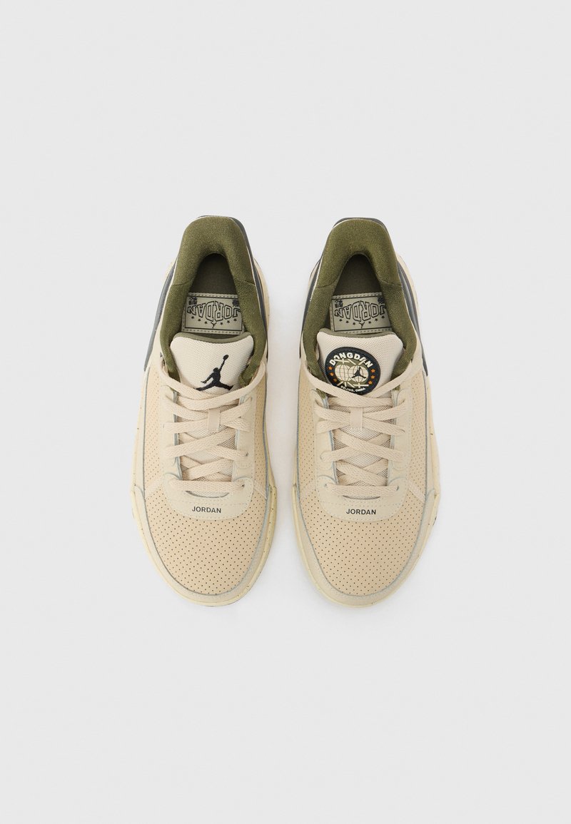 Baskets perforées beiges avec des accents vert olive, forme arrondie, lacets plats et logo Jordan sur la languette et sur le côté. Semelle en caoutchouc.