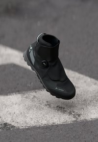 Botas de caminhada impermeáveis pretas, com cano alto, parte superior texturizada, ponta redonda e sola de borracha. Apresentam um sistema de fecho BOA e detalhes reflexivos.