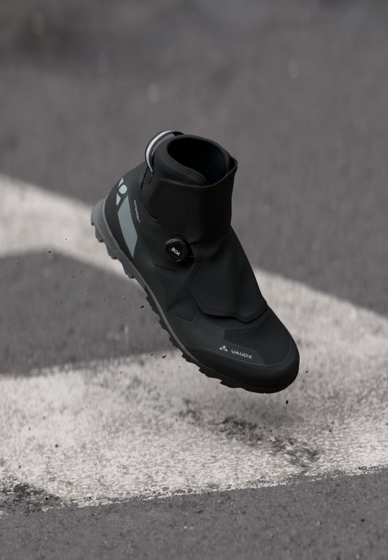 Botas de caminhada impermeáveis pretas, com cano alto, parte superior texturizada, ponta redonda e sola de borracha. Apresentam um sistema de fecho BOA e detalhes reflexivos.