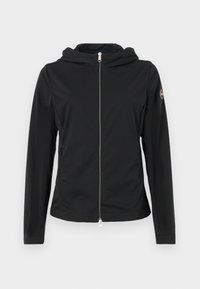 Svart lättviktsjacka med dragkedja fram, huva och två sidfickor. Har en slät textur och en logobadge på vänster ärm.