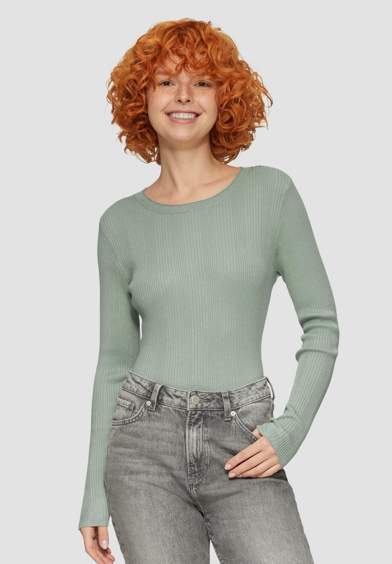 Jasnozielona, prążkowana koszula z długim rękawem i okrągłym dekoltem, zestawiona z jasnoszarymi spodniami z wysokim stanem. Prosty i przylegający fason.