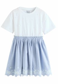 Weiße Kurzarmbluse mit strukturiertem Blumenmuster, kombiniert mit einem hellblauen, gerafften Rock, der am Saum bestickte Blumenmotive aufweist.