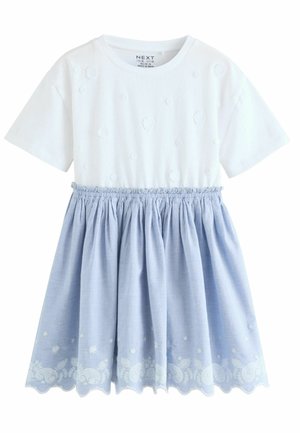 Top blanco de manga corta con un patrón floral texturizado, combinado con una falda ligera azul claro, fruncida y con detalles florales bordados en el dobladillo.