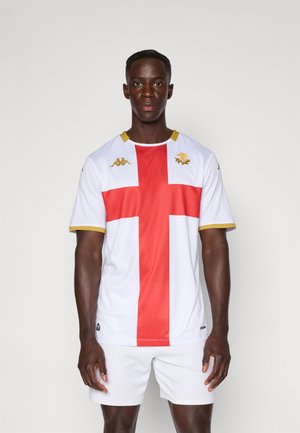 Maillot blanc avec un design en croix rouge, bordure dorée et logo Kappa. Fabriqué à partir d'un matériau athlétique texturé, porté avec un short blanc.