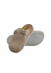 Pantofole beige senza lacci con suole in gomma bianca, cinturino regolabile e morbido rivestimento in peluche. Una ciabatta mostra la parte superiore, l'altra la suola.