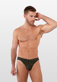 Grüne Badebriefe mit einem Blattmuster, aus weichem Stoff gefertigt, mit einem niedrig geschnittenen Design und einem elastischen Bund für zusätzlichen Komfort.