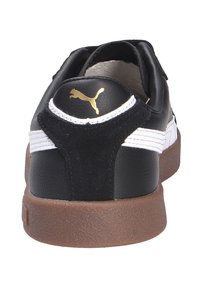 Sort sneakers i ruskind og lædermaterialer, hvide accenter, en brun gummisål og et guld logo. Lavprofil designet inkluderer en polstret krave.