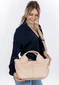 Borsa a mano in pelle rosa chiaro con manici arrotondati, cuciture visibili e tracolla staccabile. Presenta un design strutturato e una texture morbida.